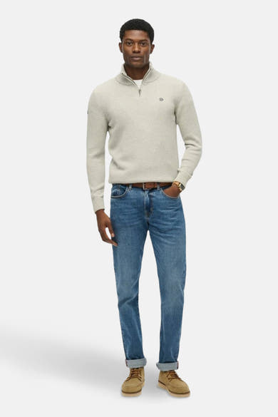 Pull à col roulé gris van SUPERDRY, porté avec un pantalon en denim bleu, ceinture marron et des chaussures marron clair.

