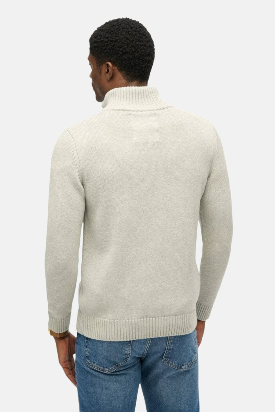 Pull à col roulé gris de SUPERDRY, vue arrière, porté avec un jean et une montre-bracelet marron.