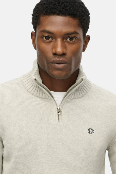 Pull à col roulé gris de Superdry, avec fermeture éclair et logo discret sur la poitrine.