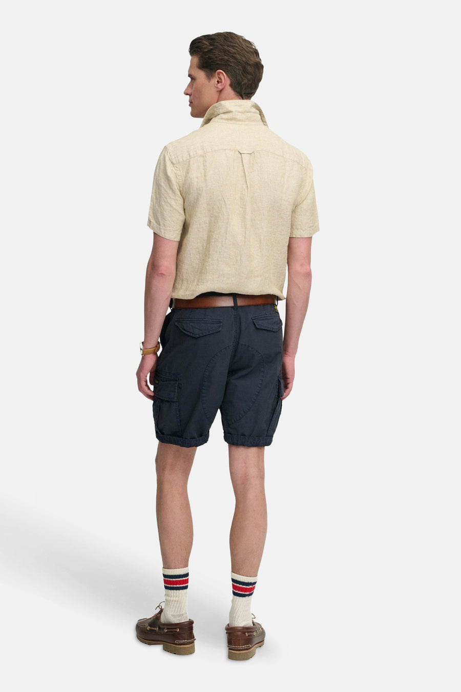 Korte blauwe cargobroek van SUPERDRY met zijzakken en opgerolde zomen, gedragen door een man van achteren.