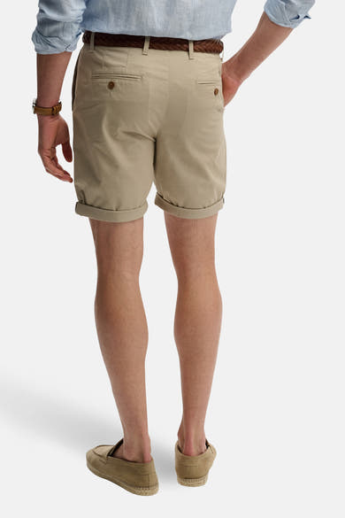 Korte beige short van SUPERDRY, met omgeslagen zoom, gedragen met een bruine riem en suède schoenen.