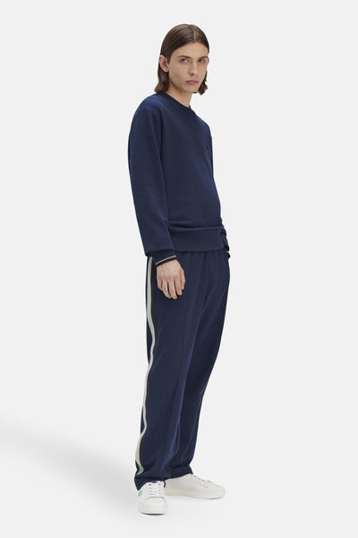 Sweat bleu, col rond de FRED PERRY, avec des bords-côtes aux poignets et un pantalon de jogging assorti.