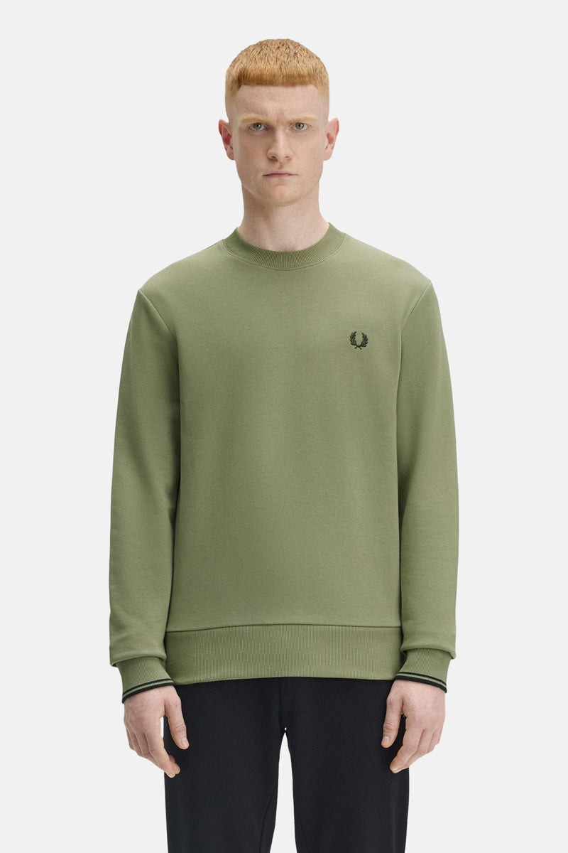 Olivengroene trui van Fred Perry, met geborduurd logo op de borst.