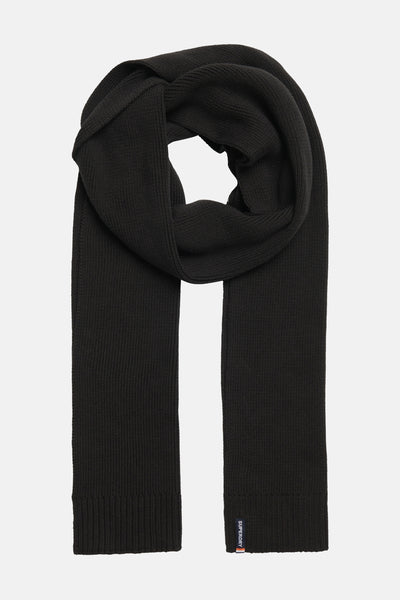 Écharpe noire en tricot de SUPERDRY, portée enroulée autour du cou, avec une étiquette de marque discrète.
