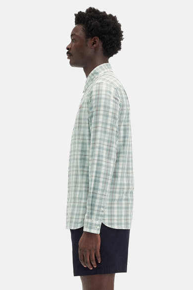 Groen geruit overhemd met korte mouwen van FRED PERRY, gedragen met een marineblauwe korte broek in profielaanzicht.