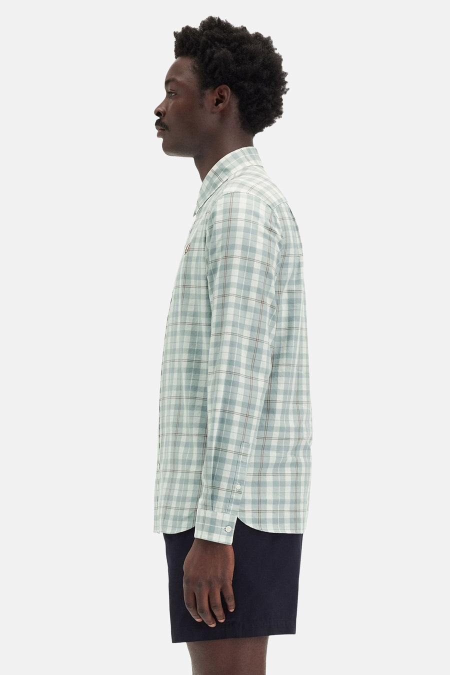 Groen geruit overhemd met korte mouwen van FRED PERRY, gedragen met een marineblauwe korte broek in profielaanzicht.