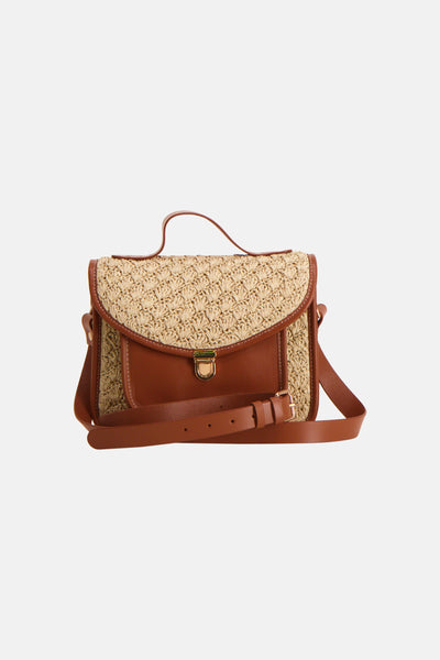 Cognac crossbody bag with woven raffia flap and leather trim, featuring a gold-tone buckle closure and adjustable strap, front view