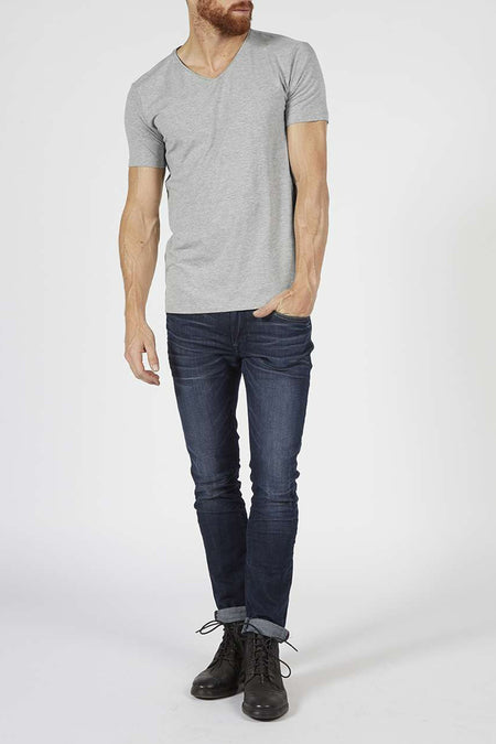 Grijs T-shirt met korte mouwen van Petrol Industries®, gedragen met een donkere jeans en zwarte laarzen.