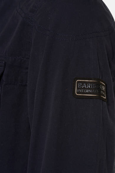 Veste de pluie bleue par BARBOUR, avec patch logo sur la manche et surpiqûres ton sur ton.
