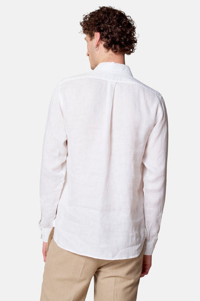 Chemise blanche à manches longues de Le Fabuleux Marcel de Bruxelles, vue de dos, portée avec un pantalon beige texturé.