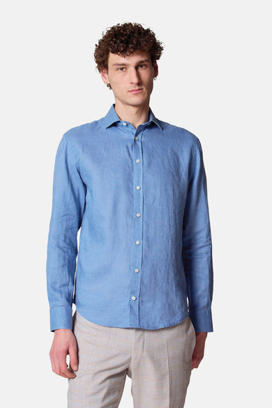Blauwe blouse met lange mouwen van Le Fabuleux Marcel de Bruxelles, van linnen, met een man die een oorbel draagt.