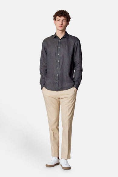 Chemise à manches longues verte par Le Fabuleux Marcel de Bruxelles, portée avec un pantalon beige.
