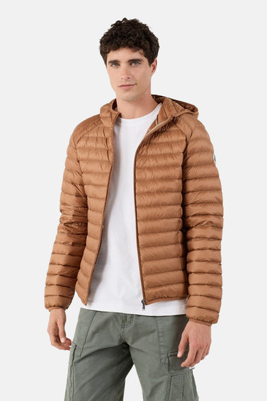 Veste de pluie marron de JOTT, avec capuche, portée sur un t-shirt blanc et un pantalon cargo vert olive.