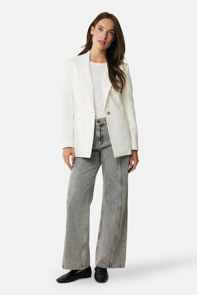 Witte blazer van MEXX, gedragen over een eenvoudig wit T-shirt en een lichtgrijze jeans.