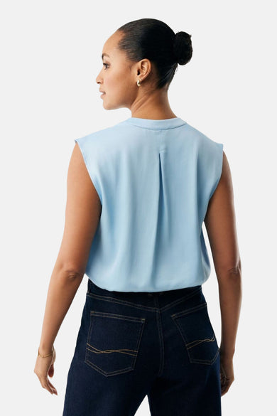 Chemisier bleu sans manches de MEXX, avec pli au dos, porté avec un jean bleu foncé.
