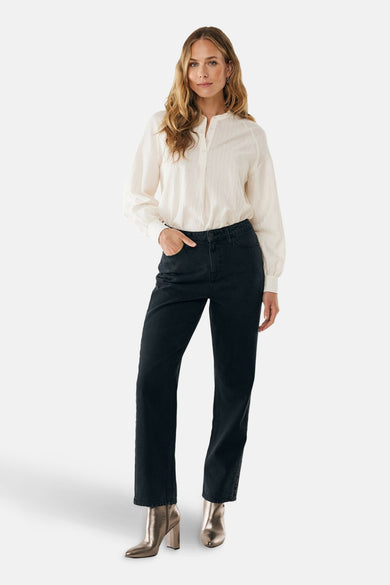 Ecru blouse met lange mouwen van MEXX, gedragen met een zwarte jeans en metallic enkellaarsjes.