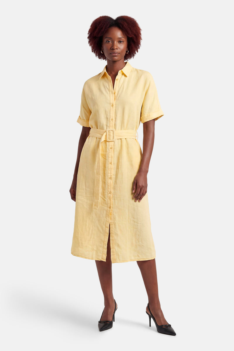 Robe jaune de MEXX, avec une ceinture assortie et des chaussures à talons noirs.