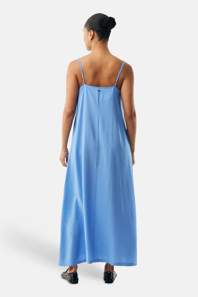 Robe longue bleue de MEXX, avec fines bretelles et coupe fluide, portée avec des ballerines à pois.
