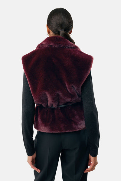 Bordeaux mouwloos vest van MEXX, zwart ceintuurdetail, gedragen met een zwarte trui en een zwarte broek.