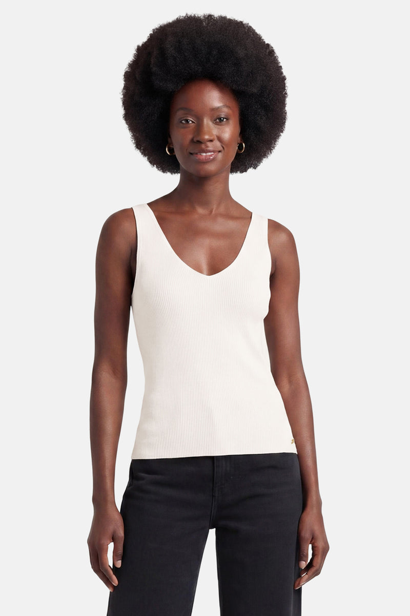 Débardeur blanc cassé de MEXX, côtelé avec col en V et petite pastille dorée.