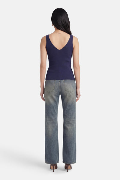 Débardeur bleu marine côtelé de MEXX avec col en V profond au dos, porté avec un jean.