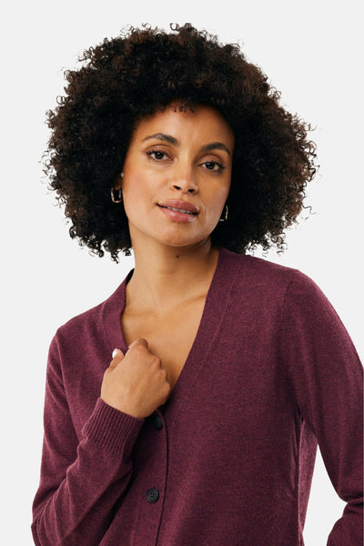 Cardigan bordeaux en maille par MEXX, porté par une femme aux cheveux bouclés, avec des boutons foncés.
