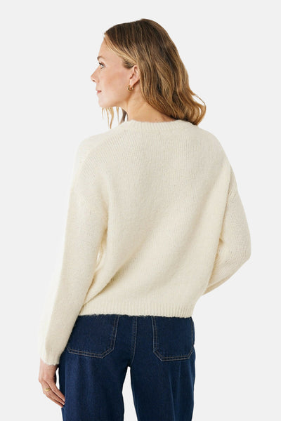 Pull à col rond écru de MEXX, porté avec un pantalon bleu marine, vue de dos.
