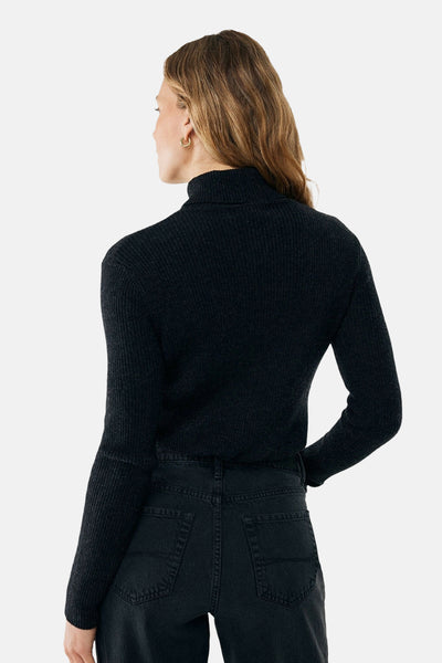 Zwarte coltrui van MEXX, met een geribbelde textuur, gedragen met een zwarte high-waist jeans.