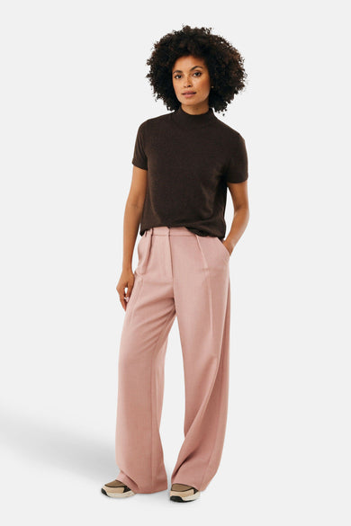 Bruine pull ras du cou van MEXX, gedragen met een ruime roze broek en sneakers.