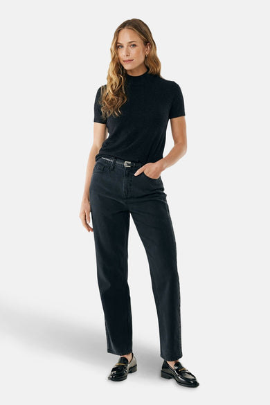 Zwarte rondehals trui van MEXX, gedragen met een zwarte jeans en lakleren loafers.
