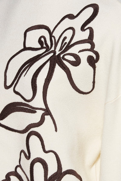 Pull à col roulé écru de MEXX, orné d'un motif floral brodé marron foncé.