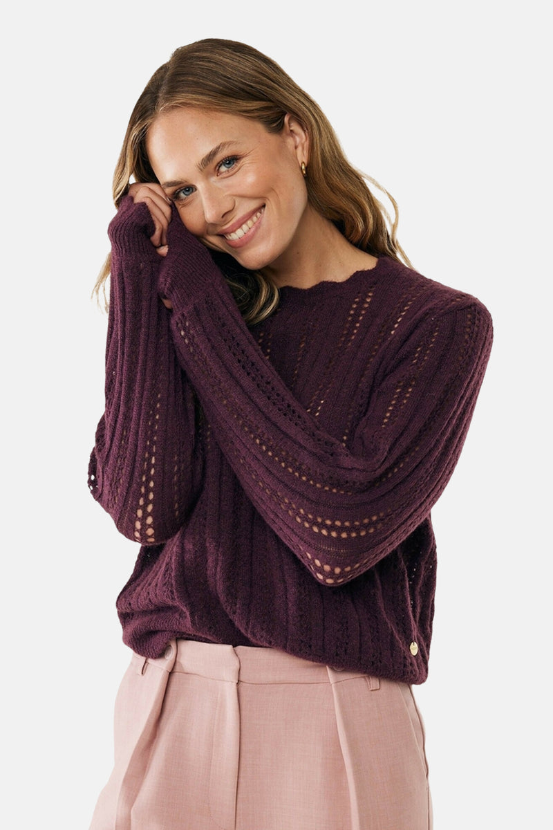 Bordeaux trui met ronde hals van MEXX, met ajourdetails en gedragen met een roze broek.