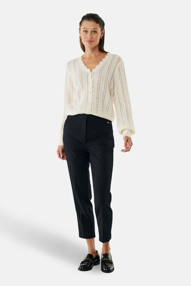 Ecru gebreid vest met ajourpatroon van MEXX, gedragen met een zwarte broek en lakleren loafers.