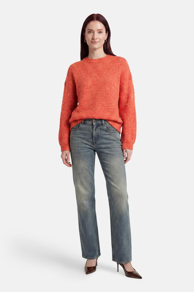Pull orange col O de MEXX tricoté, porté avec un jean et des talons marron.