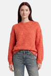 Pull col O orange de MEXX en maille texturée, porté avec un jean bleu.