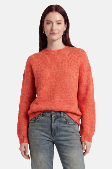 Pull col O orange de MEXX en maille texturée, porté avec un jean bleu.