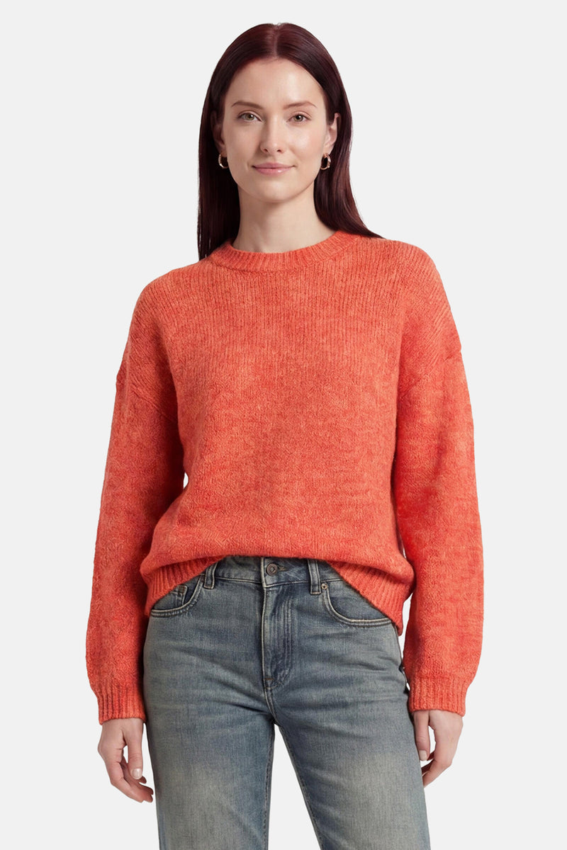 Pull col O orange de MEXX en maille texturée, porté avec un jean bleu.