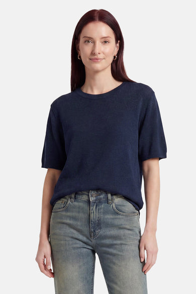 Pull col rond bleu marine de MEXX en maille, à manches courtes, porté avec un jean délavé.
