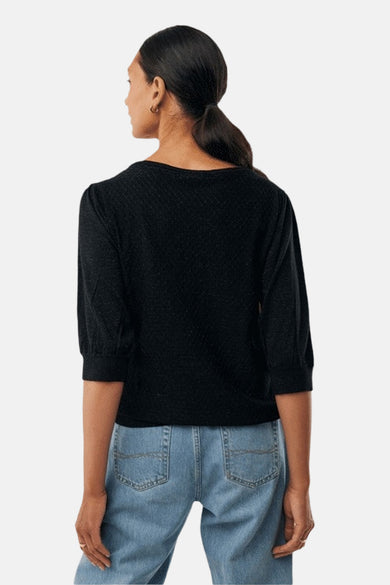 Pull à col rond noir de MEXX, manches trois-quarts et texture subtile, porté avec un jean bleu clair.
