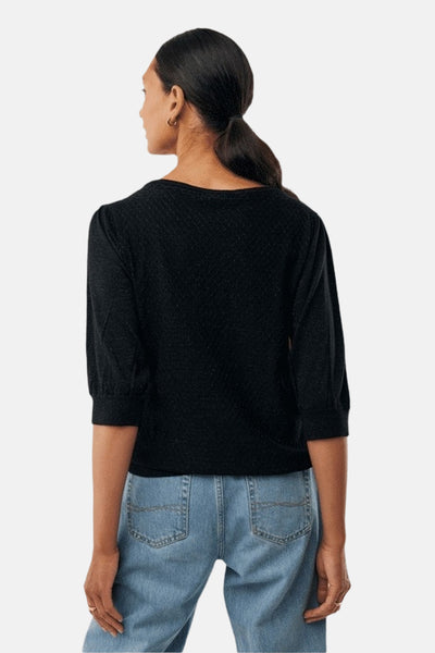 Pull à col rond noir de MEXX, manches trois-quarts et texture subtile, porté avec un jean bleu clair.
