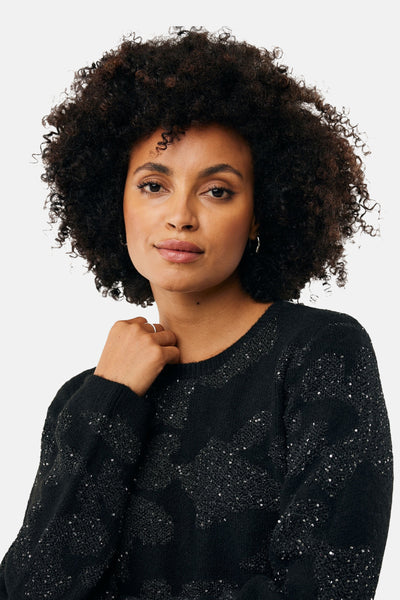 Zwarte rondehals trui van MEXX, versierd met subtiele glitterpatronen en gedragen door een vrouw.