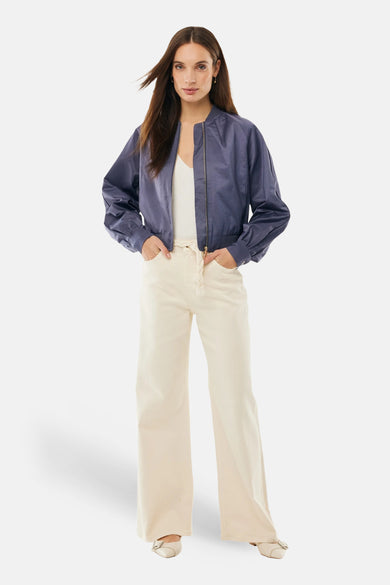 Veste courte bleue de MEXX, portée avec un débardeur blanc et un pantalon taille haute ample.