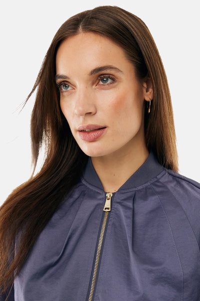 Veste courte bleue de MEXX, avec fermeture éclair dorée et col montant, portée par un mannequin.