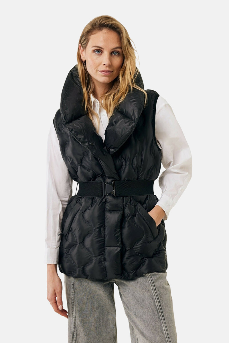 Veste courte noire par MEXX avec col montant et ceinture élastique, portée sur une chemise blanche et un jean gris.