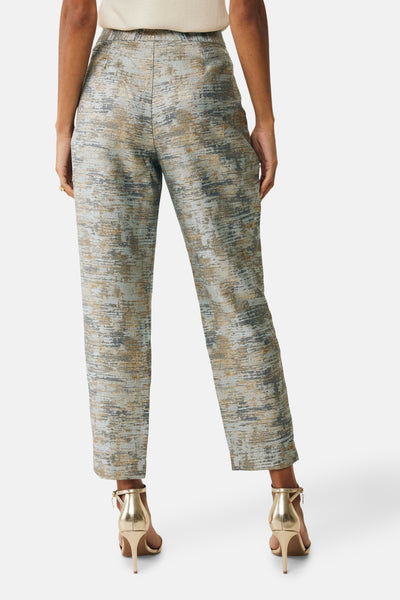 Multikleurige broek van MEXX, getextureerd met een abstracte print, gedragen met gouden naaldhakken.