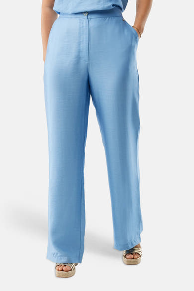Pantalon bleu de MEXX avec une texture subtile, porté avec des sandales à plateforme dorées.
