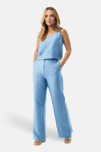 Pantalon bleu de MEXX, coupe ample avec poches et chaussures plates dorées.