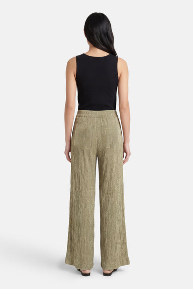 Gouden geplooide broek van MEXX, losse pasvorm, met een mouwloze zwarte top.