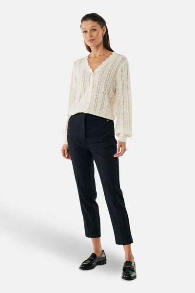 Pantalon chino 7/8 noir de MEXX, porté avec un cardigan en maille ajourée et des mocassins vernis.
