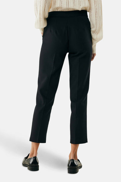 Pantalon chino 7/8 noir de MEXX, avec plis à la taille et porté avec un pull en maille ajourée.